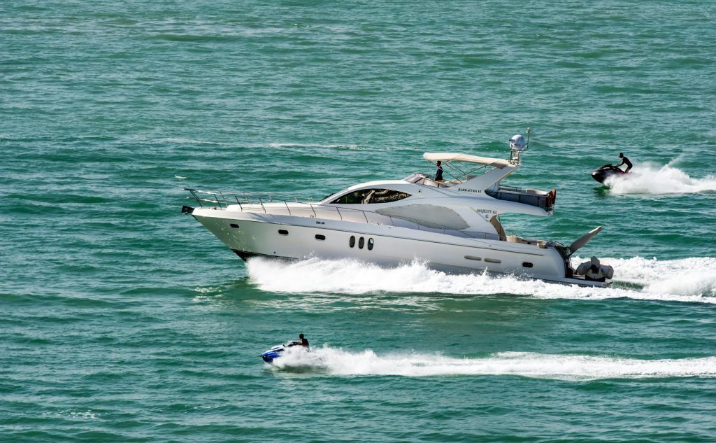 Speedboat Together with Jetskis on Body of Water