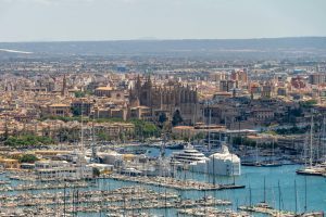 Explore the picturesque skyline of Palma de Mallorca featuring La Seu Cathedral and the bustling marina.