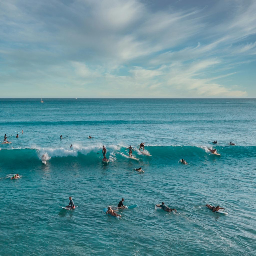 Surfers enjoy the vibrant waves of Honolulu, Hawaii's stunning oceanic panorama.