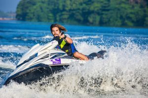 Man enjoying an exhilarating jet ski ride on water, capturing a splash of summer excitement.